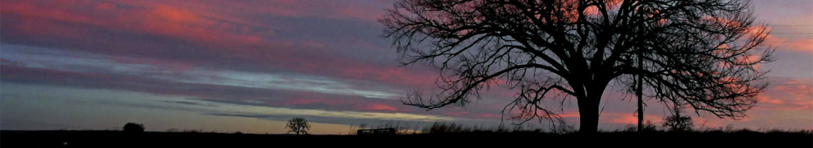 A colorful sky over an empty field.